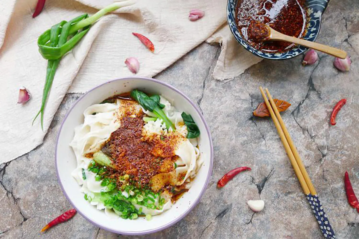 Hand-pulled wide noodles topped with garlic, scallions, and crushed chili, then doused with sizzling hot oil to awaken the aroma. This humble yet bold dish is a true taste of Shaanxi — simple, soulful, and unforgettable at Shaanxi Graden Chinese Restaurant，a Chinese Restaurant in Mesa